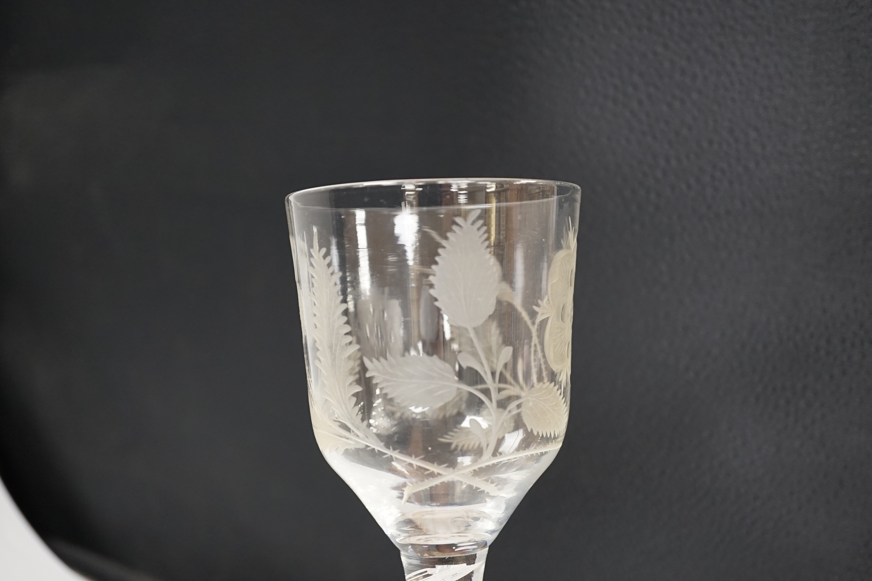 An English lead crystal Jacobite goblet, c.1750-60, bowl of ogee form, engraved with open and one closed rose and thistle, DSOT stem and plain foot with rough pontil, central gauze and multi spiral threads, tool marked,